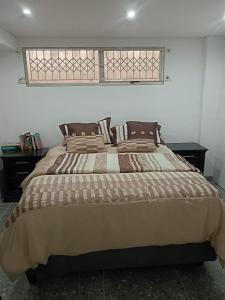 een groot bed in een slaapkamer met een raam bij Protea Place Cottage in La Mercy