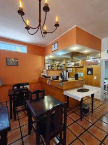 a kitchen with orange walls and a table and chairs at Hotel Portal Norte Neuquino in Chos Malal