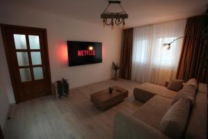 a living room with a couch and a television at Apartament la munte in Topliţa