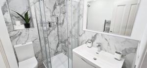 een witte badkamer met een wastafel en een douche bij One Old Creamery in Sandhead