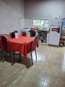 a kitchen with a red table with chairs and a refrigerator at Casa de campo Pajarito in San Fernando del Valle de Catamarca