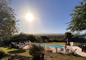 ein Pool mit Stühlen und Sonnenschirmen in einem Hof in der Unterkunft Fincas del Faldeo in Villa General Belgrano