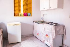 a small kitchen with a table and a refrigerator at Chalé Azul Aurora in Manhã