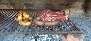a bunch of meat and vegetables on a grill at Casa de campo Pajarito in San Fernando del Valle de Catamarca