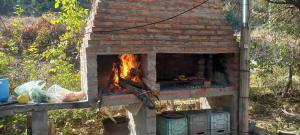 a brick oven with a fire in it at Casa de campo Pajarito in San Fernando del Valle de Catamarca +11 photos