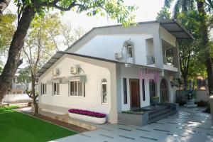 a white house with flowers in a yard at Atishay Villa I 4BHK I Pure veg I Pvt Pool & lawn in Lonavala