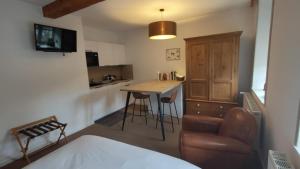 a room with a bed and a kitchen with a table at Lodge Hotel Les Rousses in Les Rousses