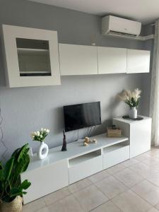a living room with a tv and white cabinets at Apartamento Carles Buïgas in Salou