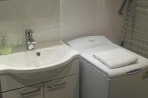 a white bathroom with a sink and a shower at Studio Willamo in Rovaniemi