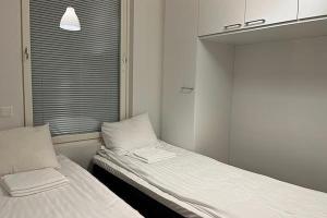 two beds in a small room with a window at Studio Willamo in Rovaniemi