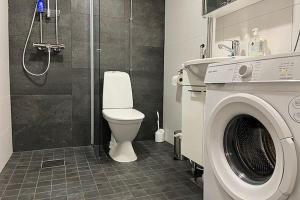 a bathroom with a toilet and a washing machine at Studio Willamo in Rovaniemi