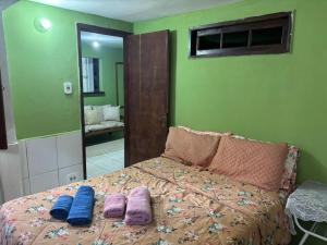 a bedroom with a bed with purple pillows and a mirror at Jully's house in Arraial do Cabo