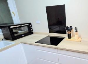 een magnetron op een aanrecht in een keuken bij One Old Creamery in Sandhead +11 foto's