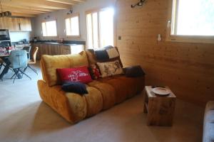 a couch with pillows on it in a living room at Chalet la Fiolaz in Châtel