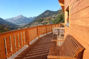 a wooden deck with a table and chairs on it at Chalet la Fiolaz in Châtel