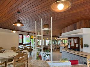 een restaurant met houten plafonds en tafels en stoelen bij Hotel Cervantes in Villa Gesell