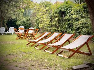 een rij loungestoelen en een tafel met stoelen bij Hotel Cervantes in Villa Gesell