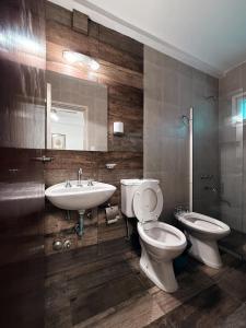 een badkamer met een wastafel, een toilet en een spiegel bij Hotel Cervantes in Villa Gesell +22 foto's