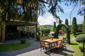 a patio with a table and chairs in front of a house at Restaurant Casa Barsan in Bîrsana
