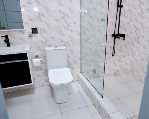 a bathroom with a toilet and a glass shower at Gravity Hotel & lofts in Ogbojo