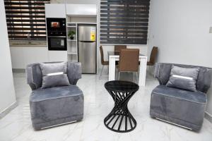 a living room with two chairs and a table at Gravity Hotel & lofts in Ogbojo