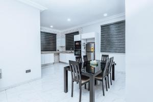 a dining room with a table and chairs and a refrigerator at Gravity Hotel & lofts in Ogbojo +3 photos