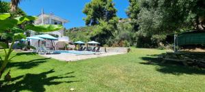 een tuin met een zwembad en een huis bij Seaside studio with swimming pool & parking #2 in Kassandria