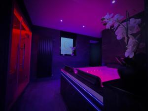 a purple room with a tub with a pink light at L' Instant Se Crée in Oignies