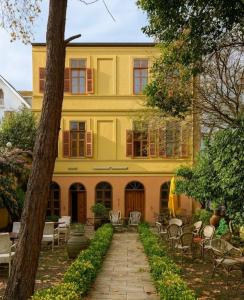 a yellow building with tables and chairs in front of it at Anthea Butik Otel in Adalar +22 photos