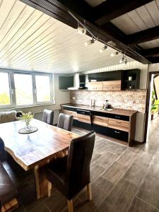 a large kitchen with a wooden table and chairs at LUMI Living in Schlüsselfeld