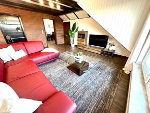 a living room with a red couch and a television at LUMI Living in Schlüsselfeld