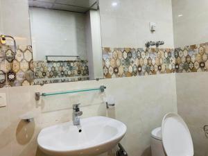 a bathroom with a sink and a toilet and a mirror at Pavilion 99 Serenity Appartment 2bhk in Rawalpindi