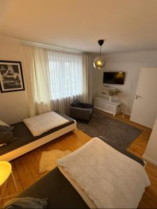 een woonkamer met 2 bedden en een televisie bij Geräumige Wohnfühloase mit 3 Schlafzimmern in Garbsen +8 foto's