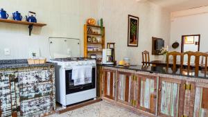 a kitchen with a stove and a refrigerator at casa de mineiro in Tiradentes