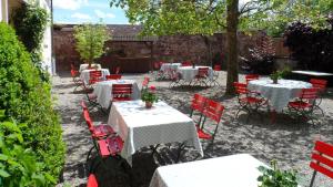 eine Terrasse mit weißen Tischen und roten Stühlen in der Unterkunft Hotel Scheidels Kranz in Kenzingen