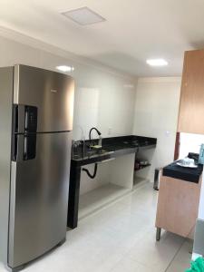a kitchen with a stainless steel refrigerator and a counter at Apartamento Piúma in Piúma