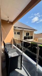 a balcony with chairs and a view of a house at Cherry Signature Condos in Adentan