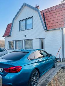 a blue car parked in front of a house at Solgården in Falkenberg +7 photos