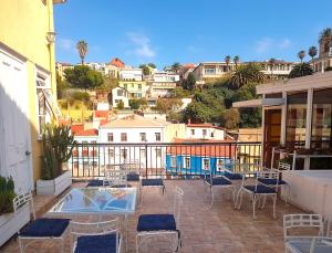 a patio with chairs and tables and a view of a city at La Galería B&B in Valparaíso