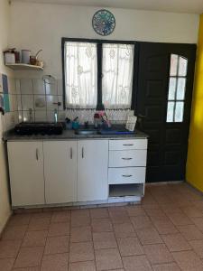 een keuken met witte kasten en een zwarte deur bij Jacaranda 3 in Agua de Oro