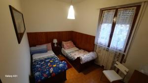 ein kleines Schlafzimmer mit einem Bett und einem Fenster in der Unterkunft Casa Kelly in Luni