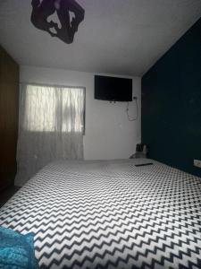 een slaapkamer met een bed en een flatscreen-tv bij Jacaranda 3 in Agua de Oro