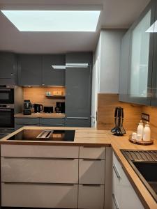 eine Küche mit weißen Schränken und einem großen Waschbecken in der Unterkunft Harz High End Fewo Stefanie 4 Sterne DTV in Goslar