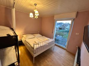 een slaapkamer met een bed en een raam bij Seeblick Hotel-Ferienhaus- Obermaubach in Kreuzau