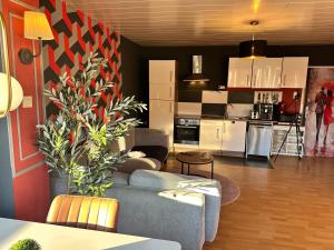 een woonkamer met een bank en een keuken bij Seeblick Hotel-Ferienhaus- Obermaubach in Kreuzau