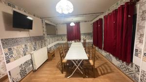 een eetkamer met een tafel en rode gordijnen bij Gîte Arcis sur Aube in Arcis-sur-Aube