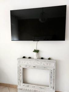 einen Flachbild-TV an einer weißen Wand in der Unterkunft La Finestra sulla Storia in Asti