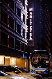 een bus die door een straat rijdt voor een gebouw bij Maritztel Bangkok Hotel in Ban Bang Toei (1)