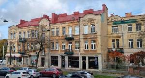 a large building with cars parked in front of it at Basanavičiaus apartament in Vilnius