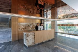 twee mannen staan aan een balie in een lobby bij Maritztel Bangkok Hotel in Ban Bang Toei (1) +13 foto's